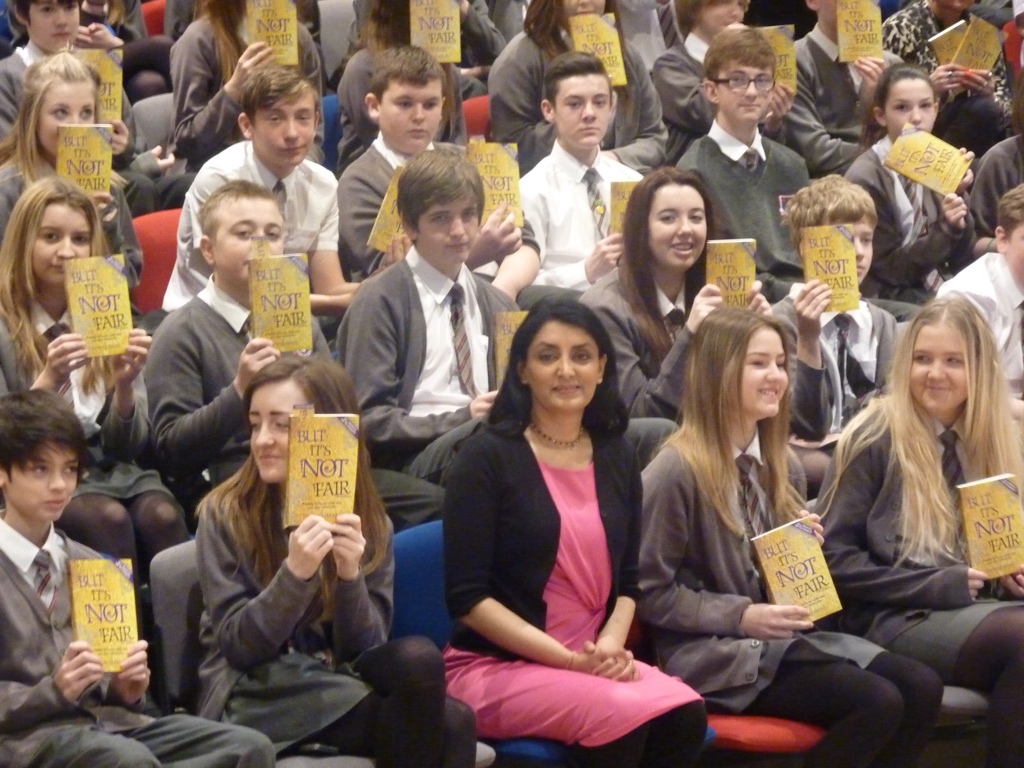 Aneeta Prem with pupils holding the gold edition of But It's Not Fair