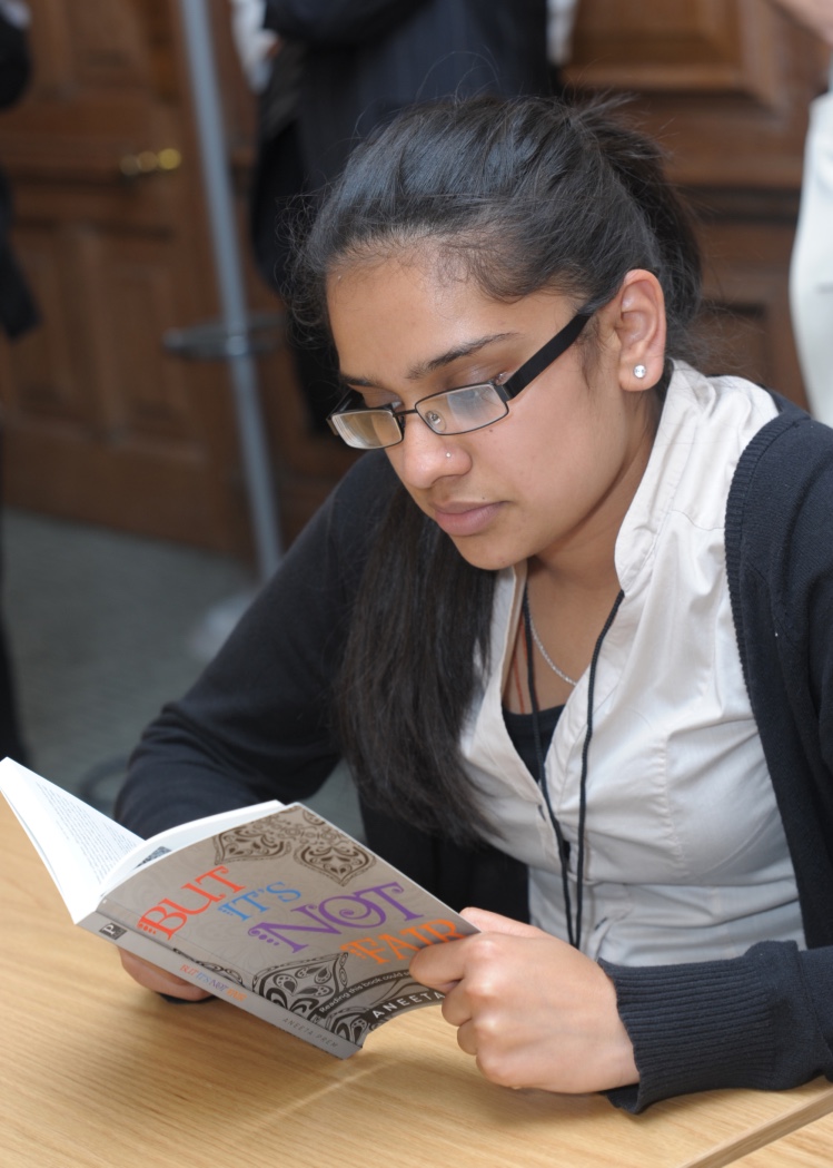 A pupil reading But It's Not Fair