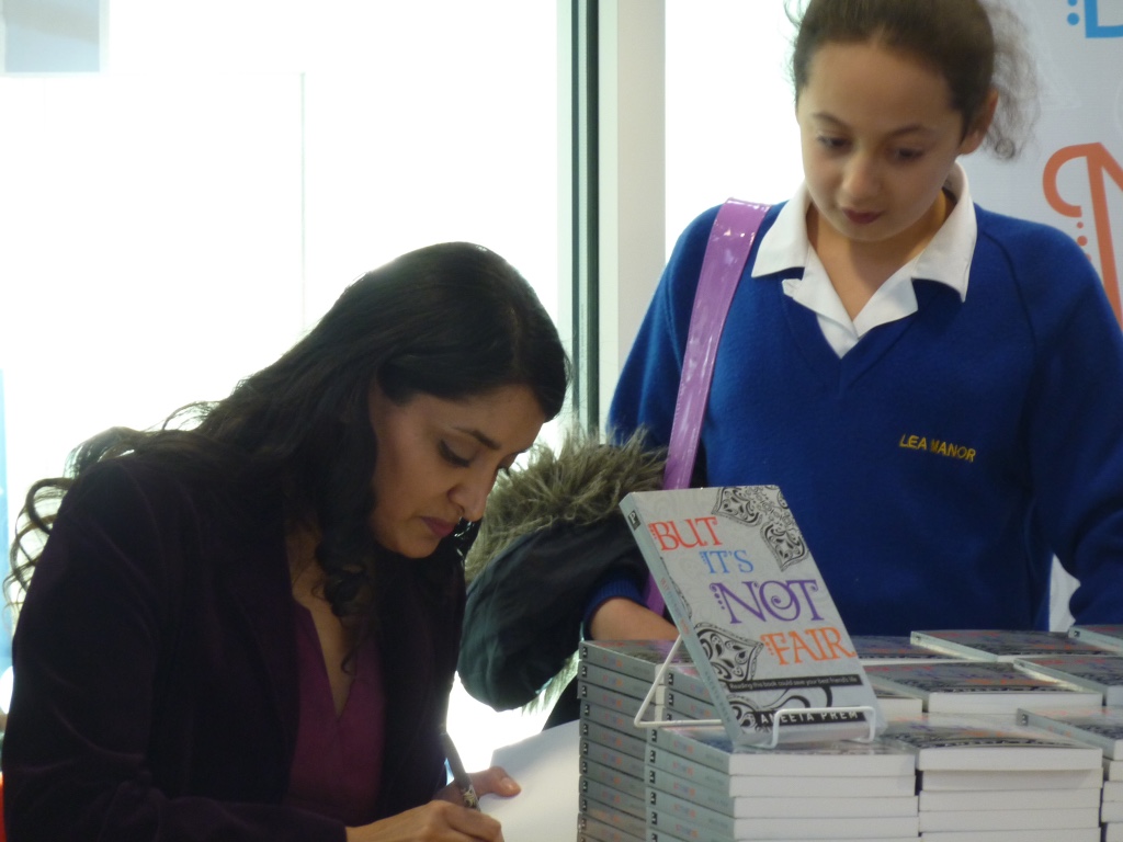 Aneeta Prem signing a copy of But It's Not Fair for a pupil